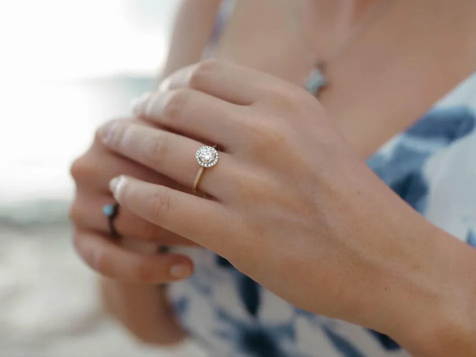 Close-up of a hand wearing a diamond ring.