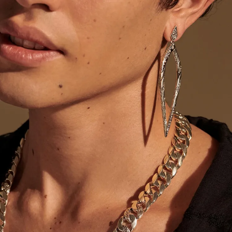 Earrings and chain necklace on a person.