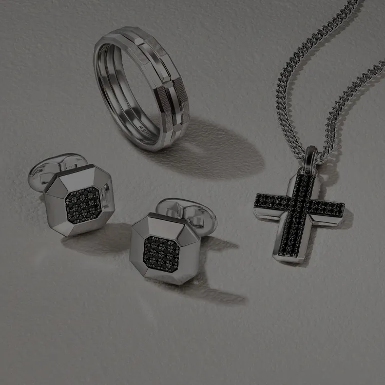 Men's silver ring, cufflinks, and black cross necklace on display.