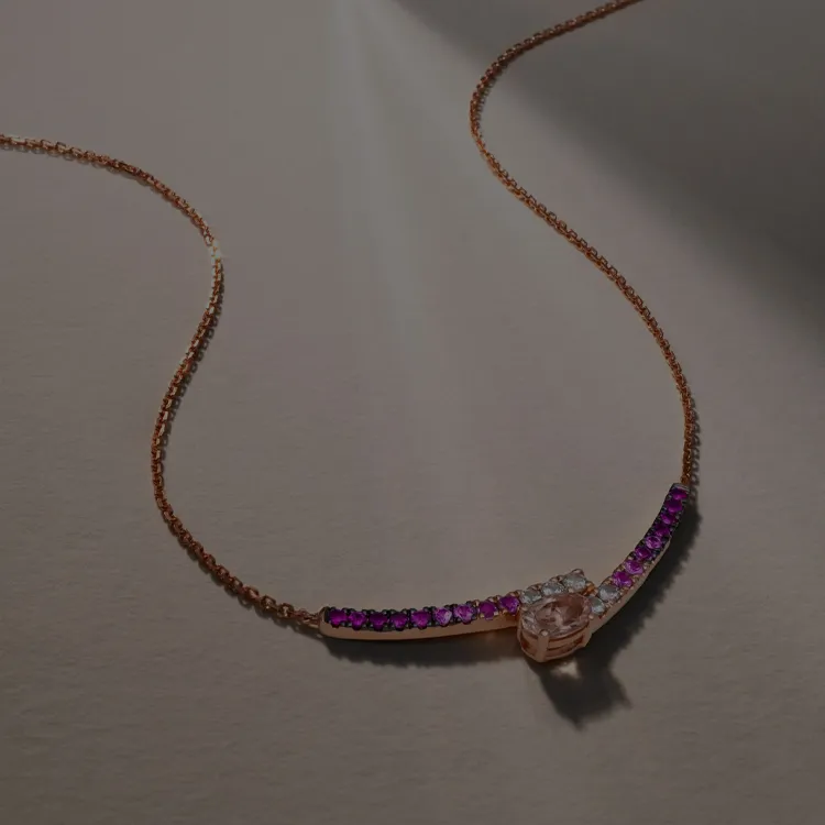Elegant necklace with pink and white stones on a gold chain.