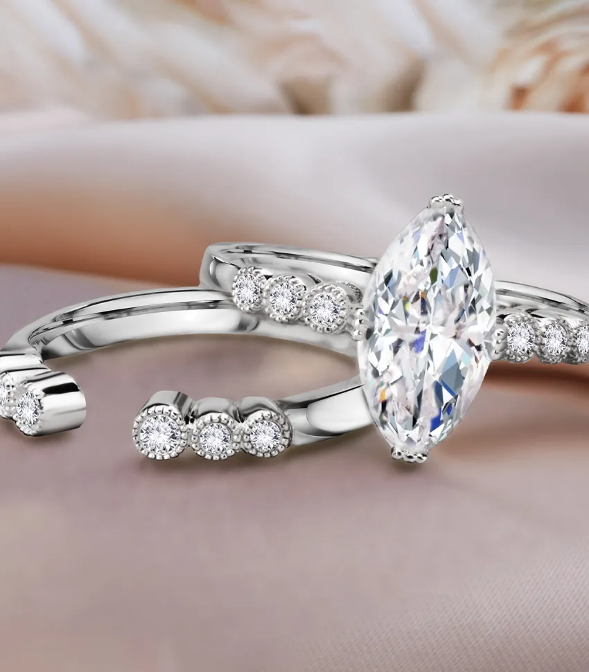 Elegant silver rings featuring a marquise diamond and smaller diamonds, perfect for engagement. 