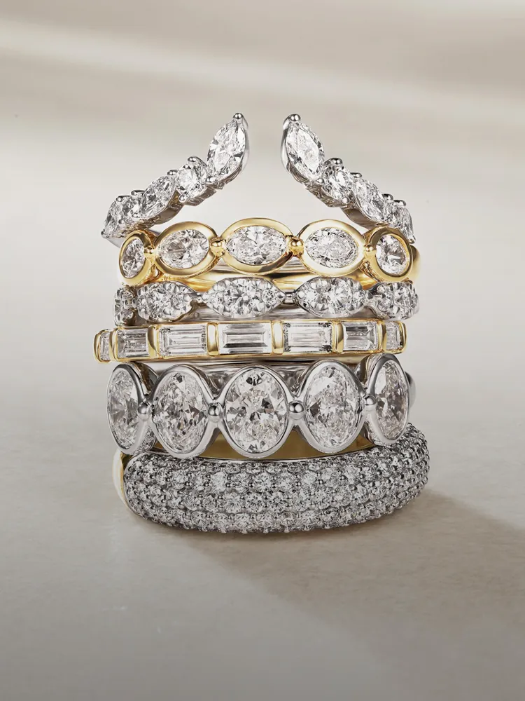 Stack of elegant diamond wedding bands in gold and silver, showcasing various styles and designs. Shop at Bryan Jewelry.