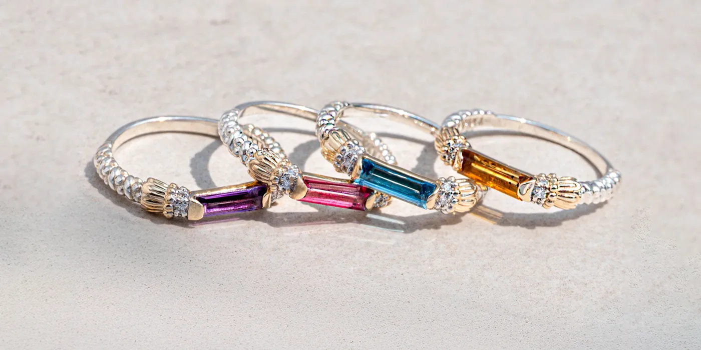Four colorful gemstone rings with silver bands displayed on a light surface. Shop at Bryan Jewelry in Prattville.