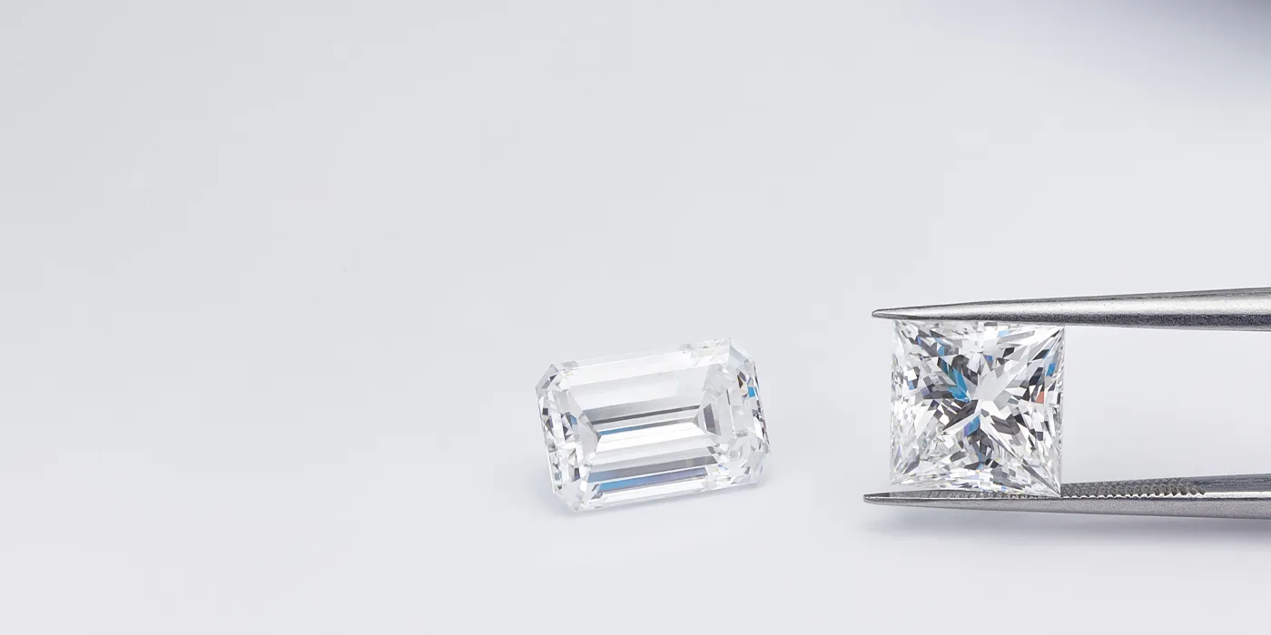 Two sparkling diamonds, one held by tweezers, showcasing bespoke luxury at Bryan Jewelry in Prattville.