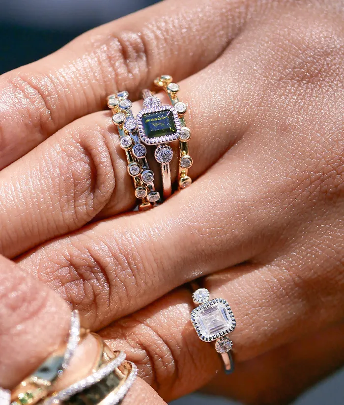 Elegant stacked rings featuring a green gemstone and sparkling diamonds, showcasing fine jewelry from Bryan Jewelry in Prattvill