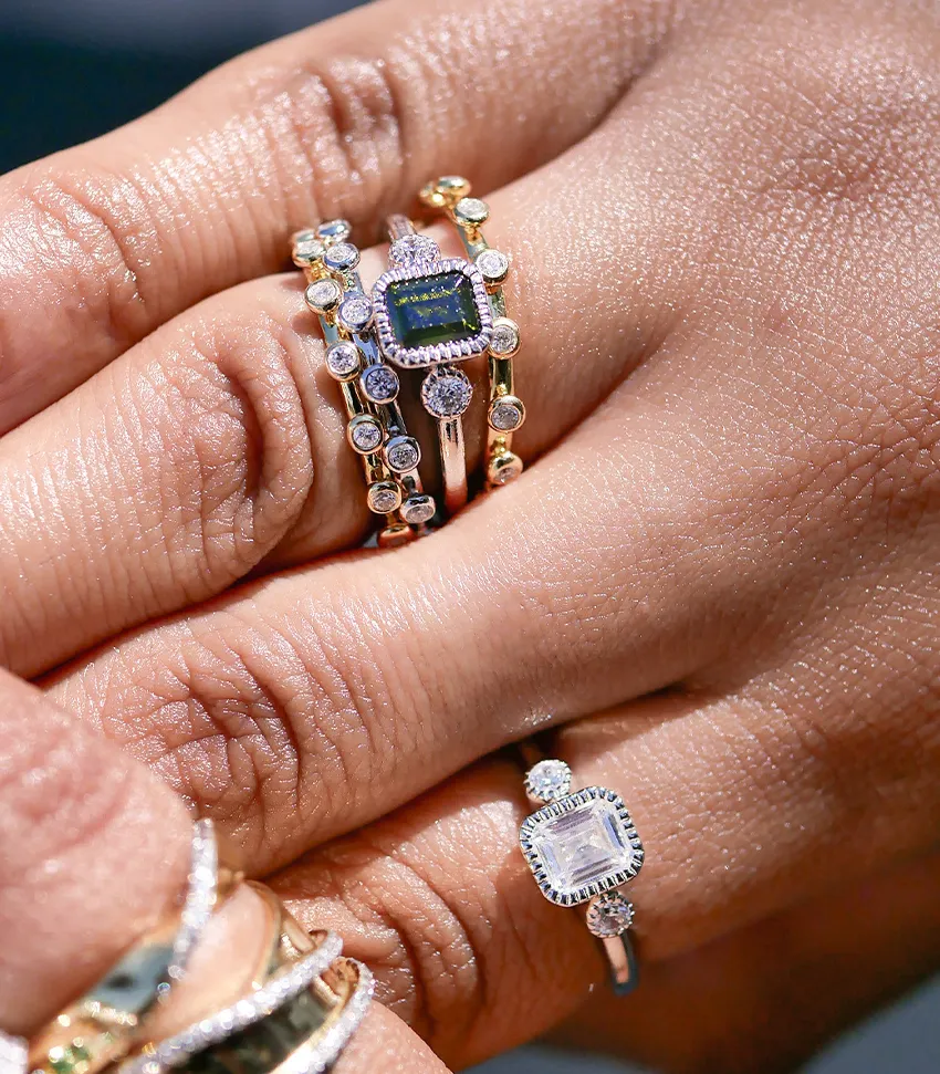 Elegant stacked rings featuring a green gemstone and sparkling diamonds, showcasing fine jewelry from Bryan Jewelry in Prattvill