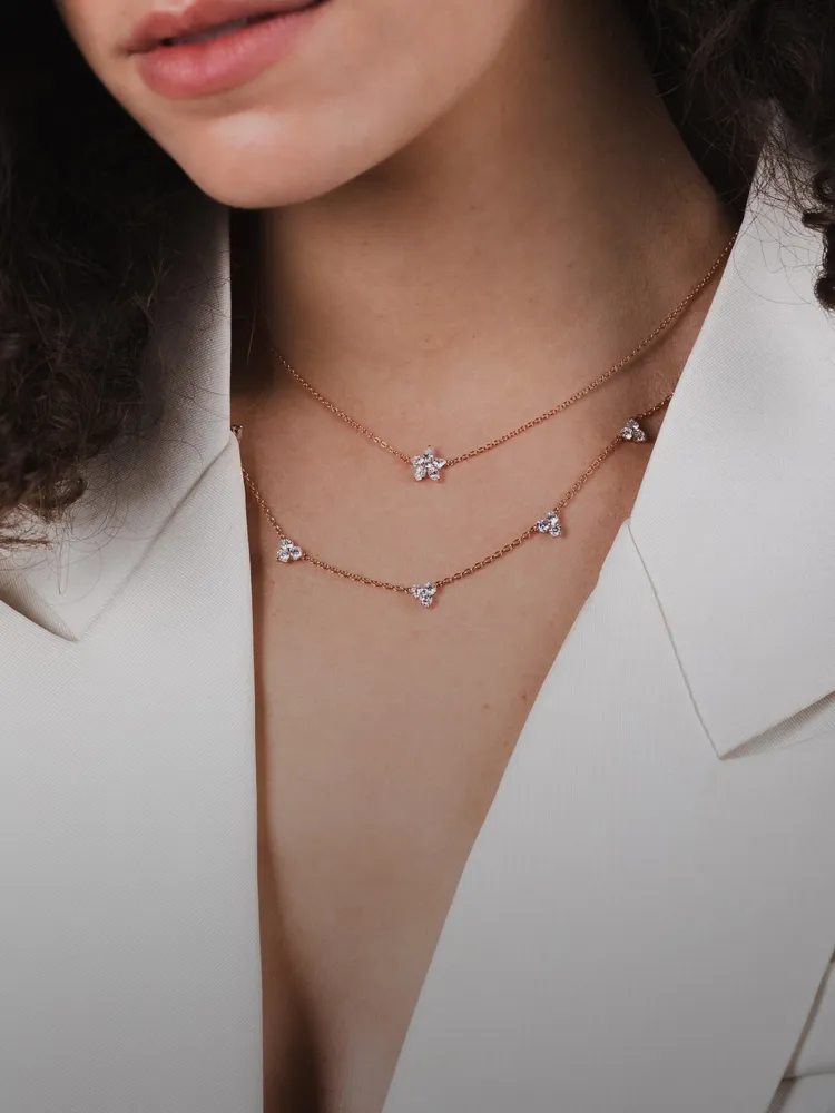 Model wearing layered rose gold necklaces with sparkling stones, promoting Bryan Jewelry's necklace collection.