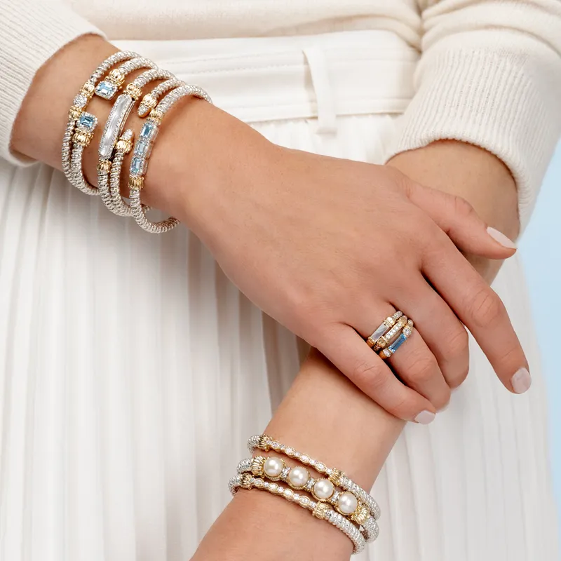 Elegant bracelets and rings featuring pearls and gemstones, styled on a model's hands. Shop at Bryan Jewelry in Prattville.