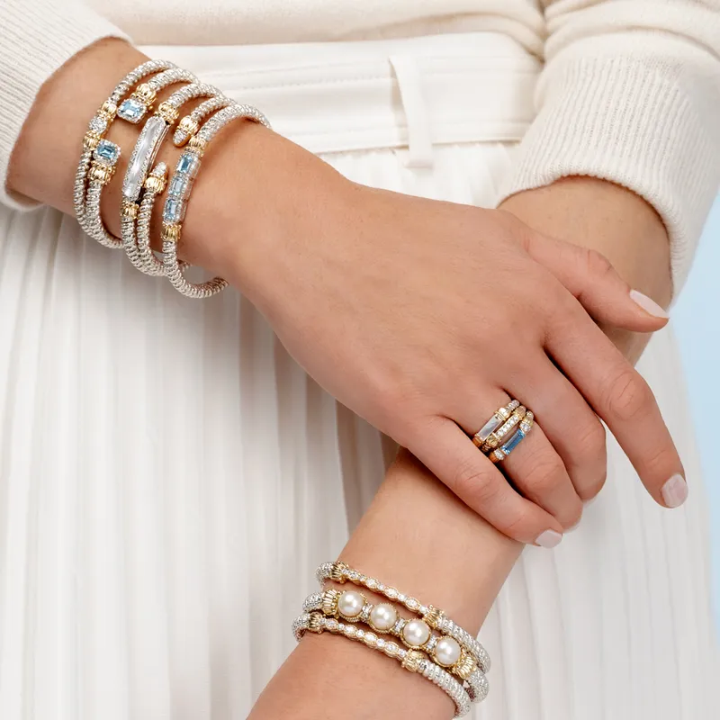 Elegant bracelets and rings featuring pearls and gemstones, styled on a model's hands. Shop at Bryan Jewelry in Prattville.