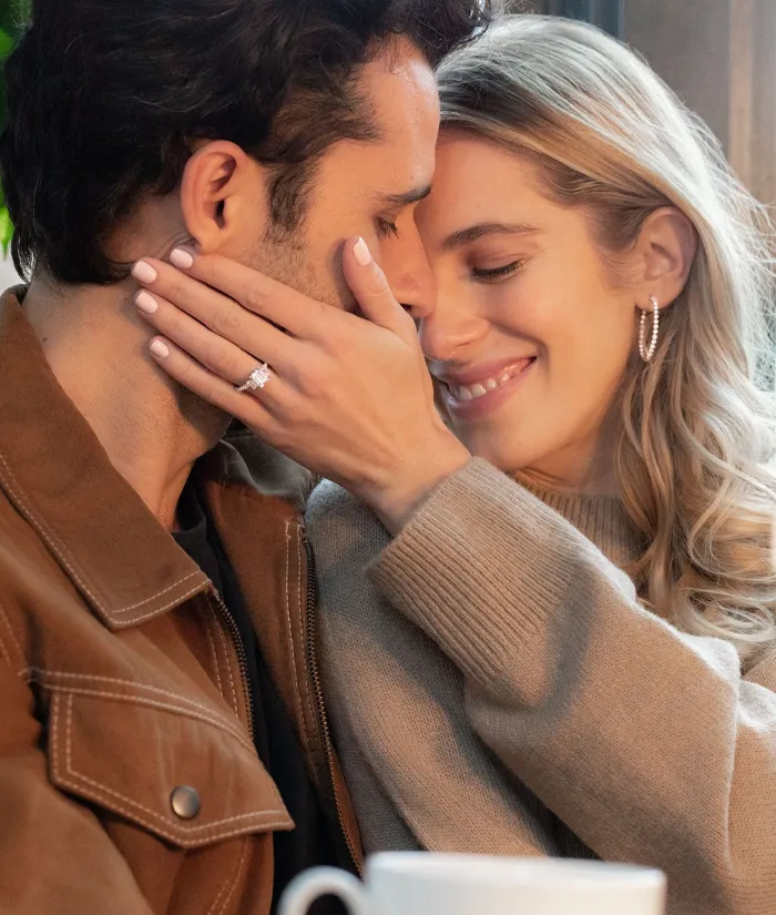 Couple sharing a romantic moment, showcasing an engagement ring. Visit Bryan Jewelry for fine jewelry in Prattville.
