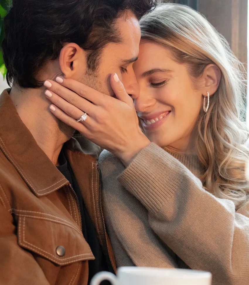 Couple sharing a romantic moment, showcasing an engagement ring. Visit Bryan Jewelry for fine jewelry in Prattville.