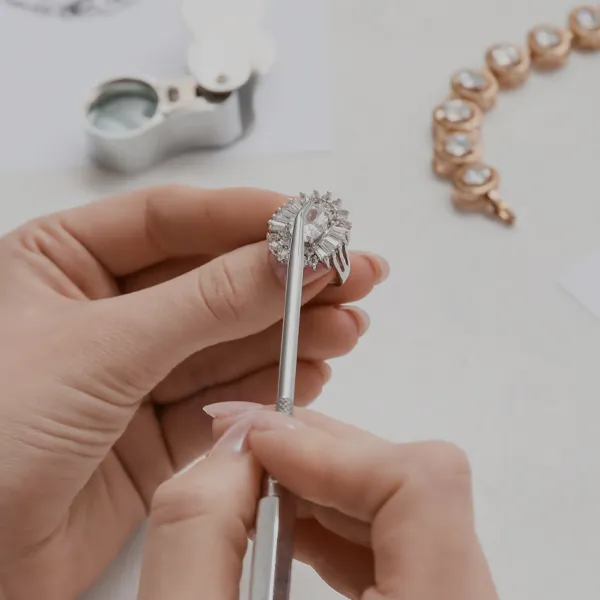A person inspects a diamond ring with a tool, showcasing fine jewelry craftsmanship at Bryan Jewelry in Prattville.