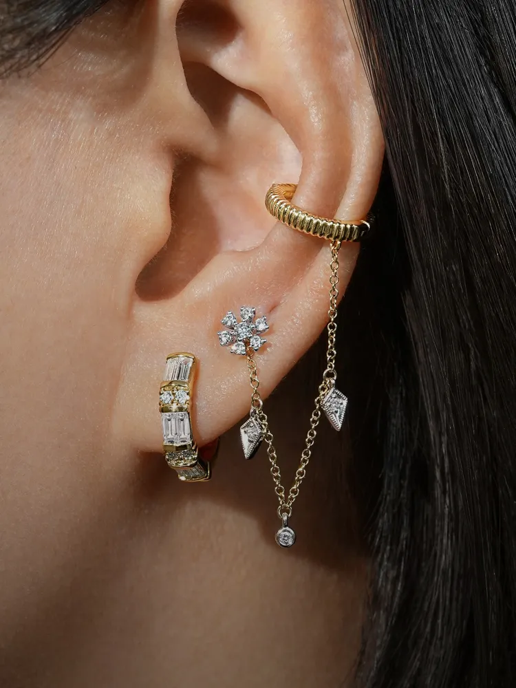 Gold and diamond earrings displayed on a model's ear. Shop earrings at Bryan Jewelry, Prattville's fine jewelry store.