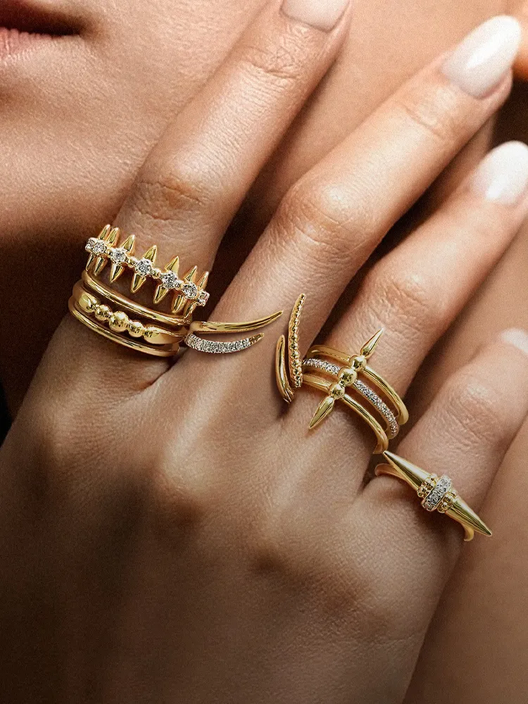 Stylish gold rings with diamonds on a hand, showcasing a variety of designs. Shop rings at Bryan Jewelry in Prattville.