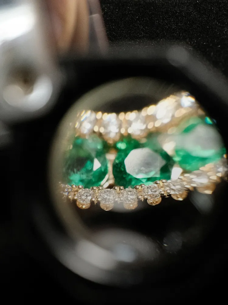 Close-up view of emerald and diamond jewelry, showcasing intricate details. Click to learn about appraisals at Bryan Jewelry.