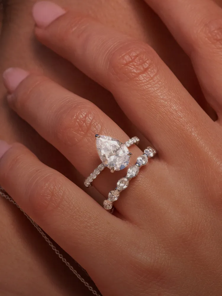 Elegant pear-shaped diamond ring with two sparkling bands on a hand, showcasing fine jewelry from Bryan Jewelry in Prattville.