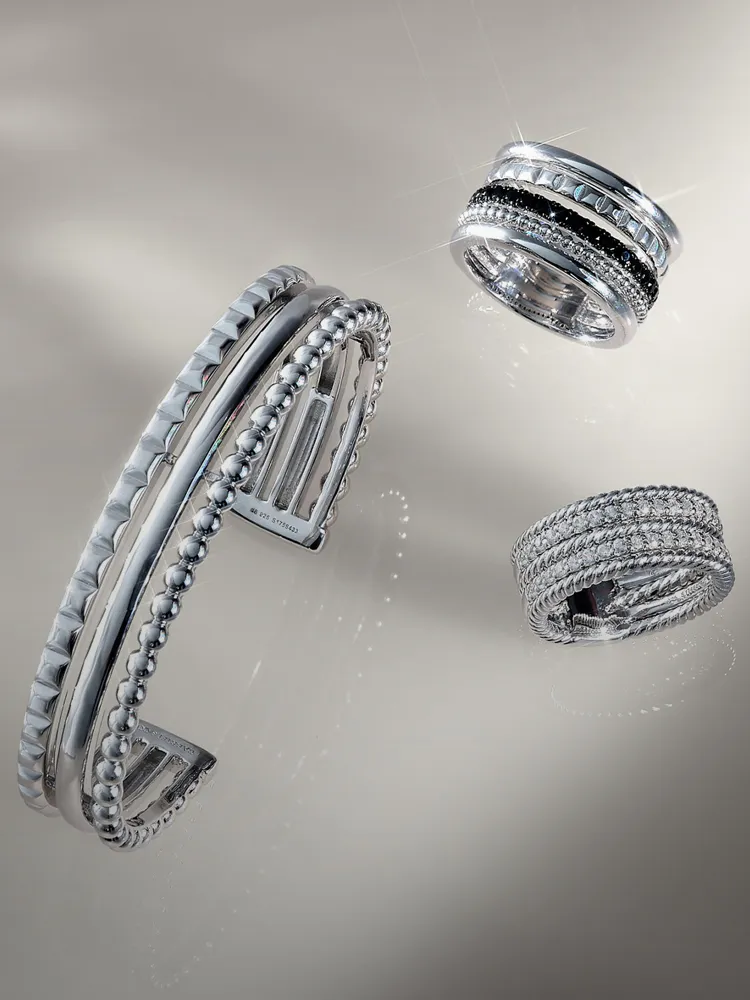 Three elegant silver rings and a cuff bracelet displayed against a soft background. Click for jewelry repair services.