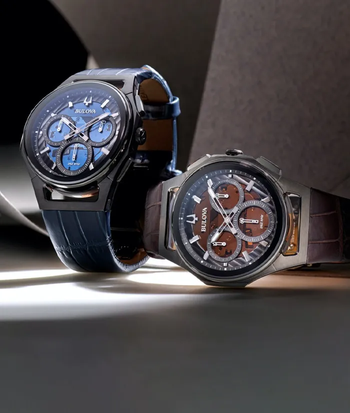 Two stylish Bulova watches, one blue and one brown, displayed elegantly on a dark background.