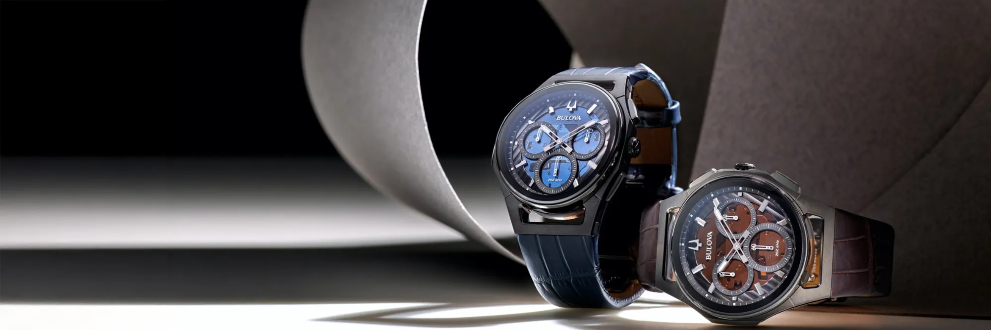 Two stylish Bulova watches, one blue and one brown, displayed elegantly on a dark background.