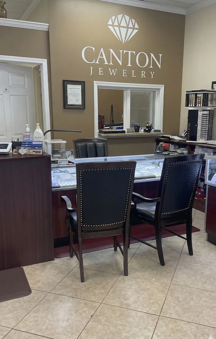 Canton Jewelry showroom interior with display cases and branded wall in Canton Marketplace. Make an Appointment.