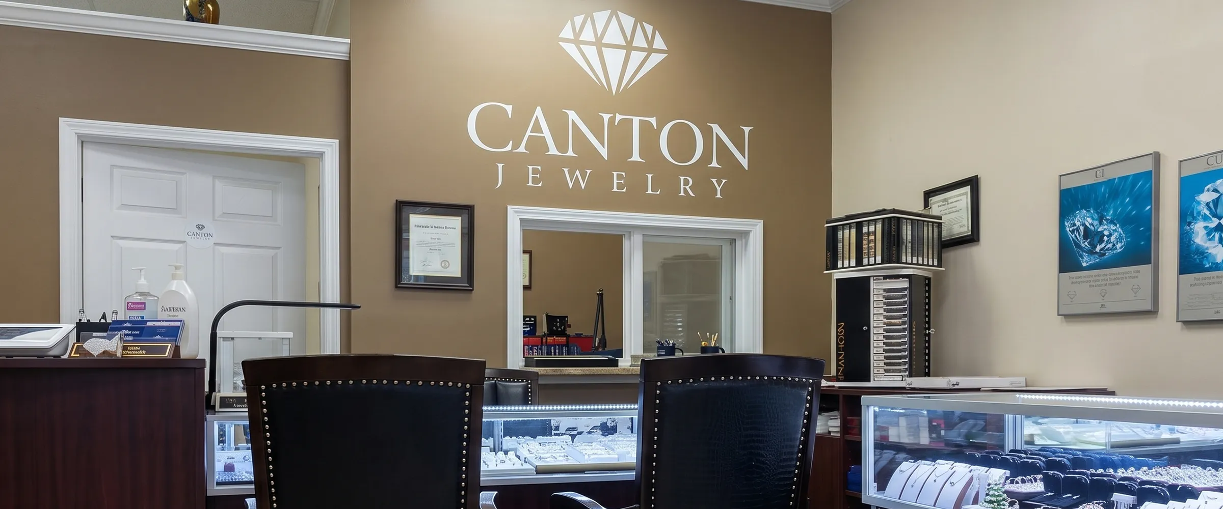 Canton Jewelry showroom interior with display cases and branded wall in Canton Marketplace. Make an Appointment.