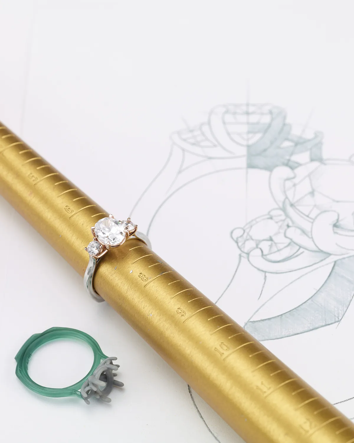 Ring on a sizing tool with a design sketch and wax model. Learn more.