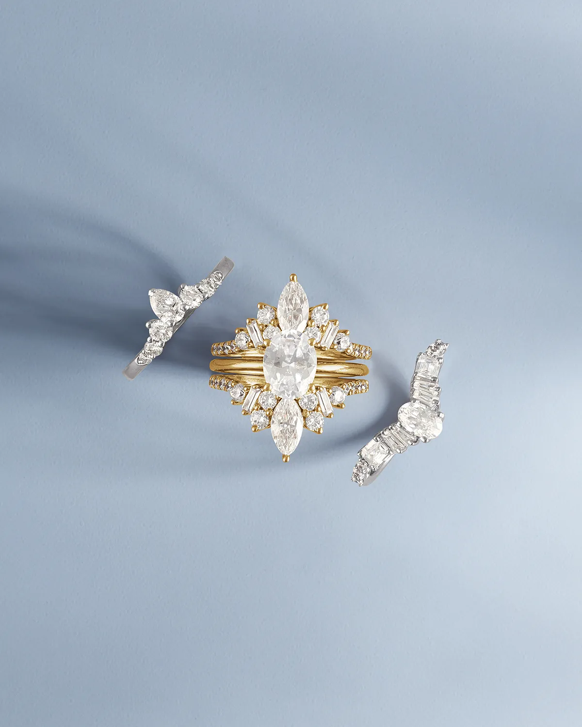 Three diamond rings on a light blue background. Click to shop diamonds.