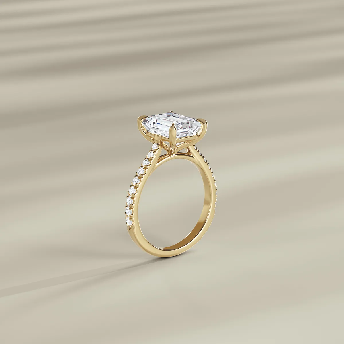 Gold engagement ring with large diamond and smaller diamonds on band, displayed on a beige background.