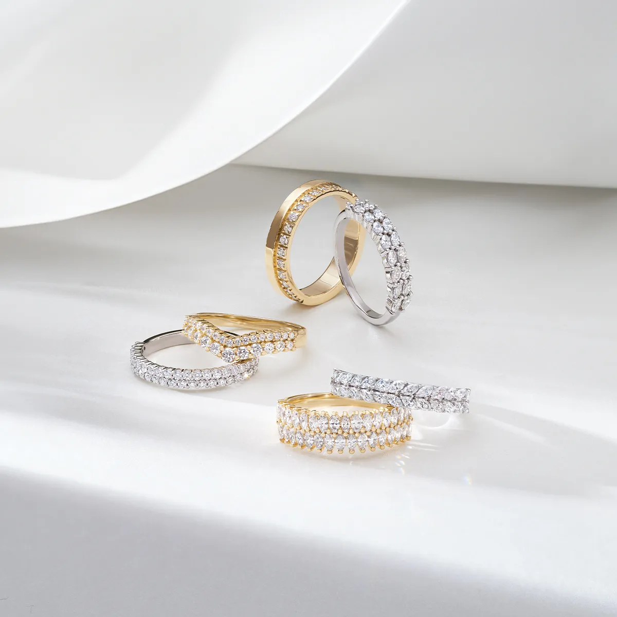 Gold and silver diamond wedding bands displayed on a white surface.