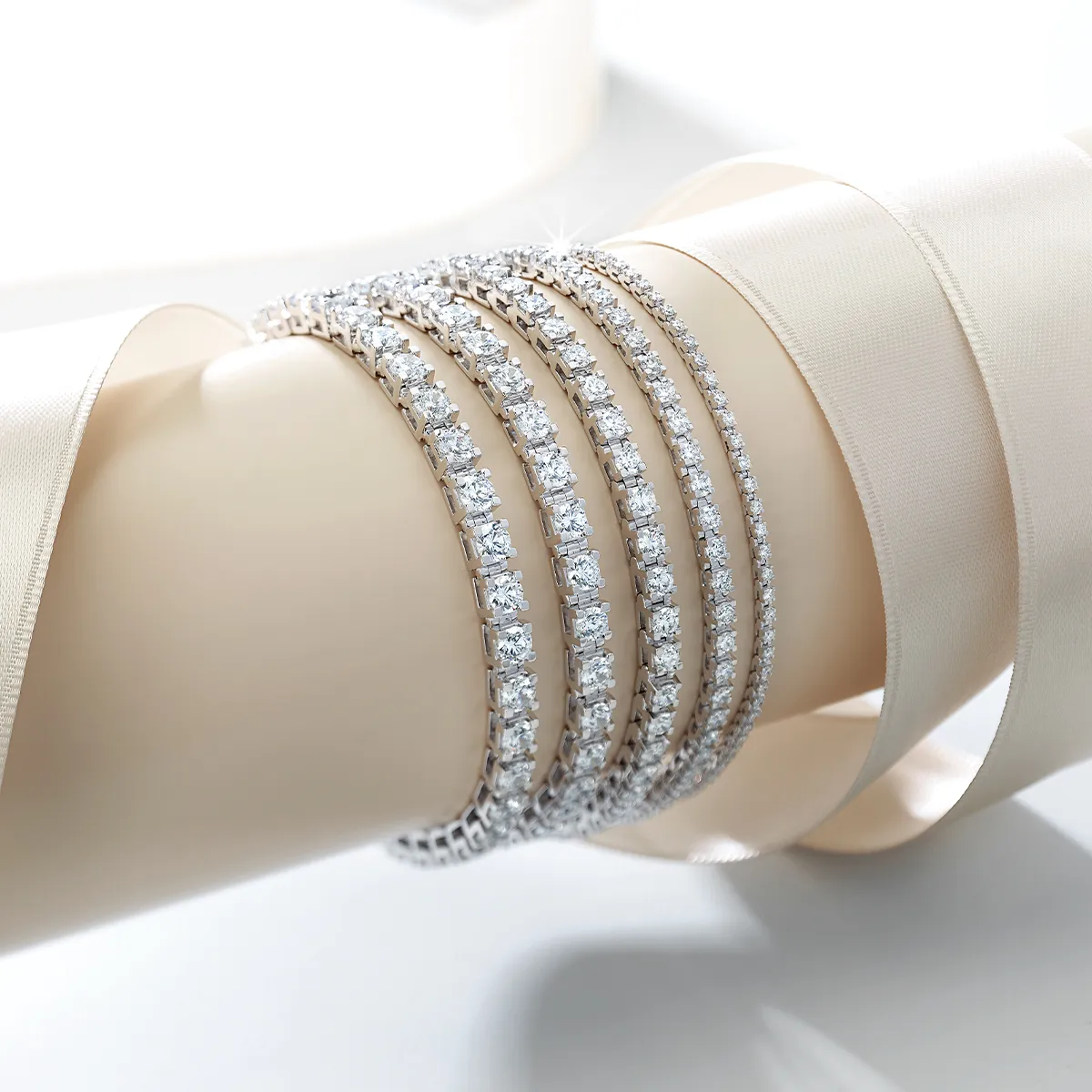 Elegant lab-grown diamond bracelets displayed on a beige surface with ribbon accents.
