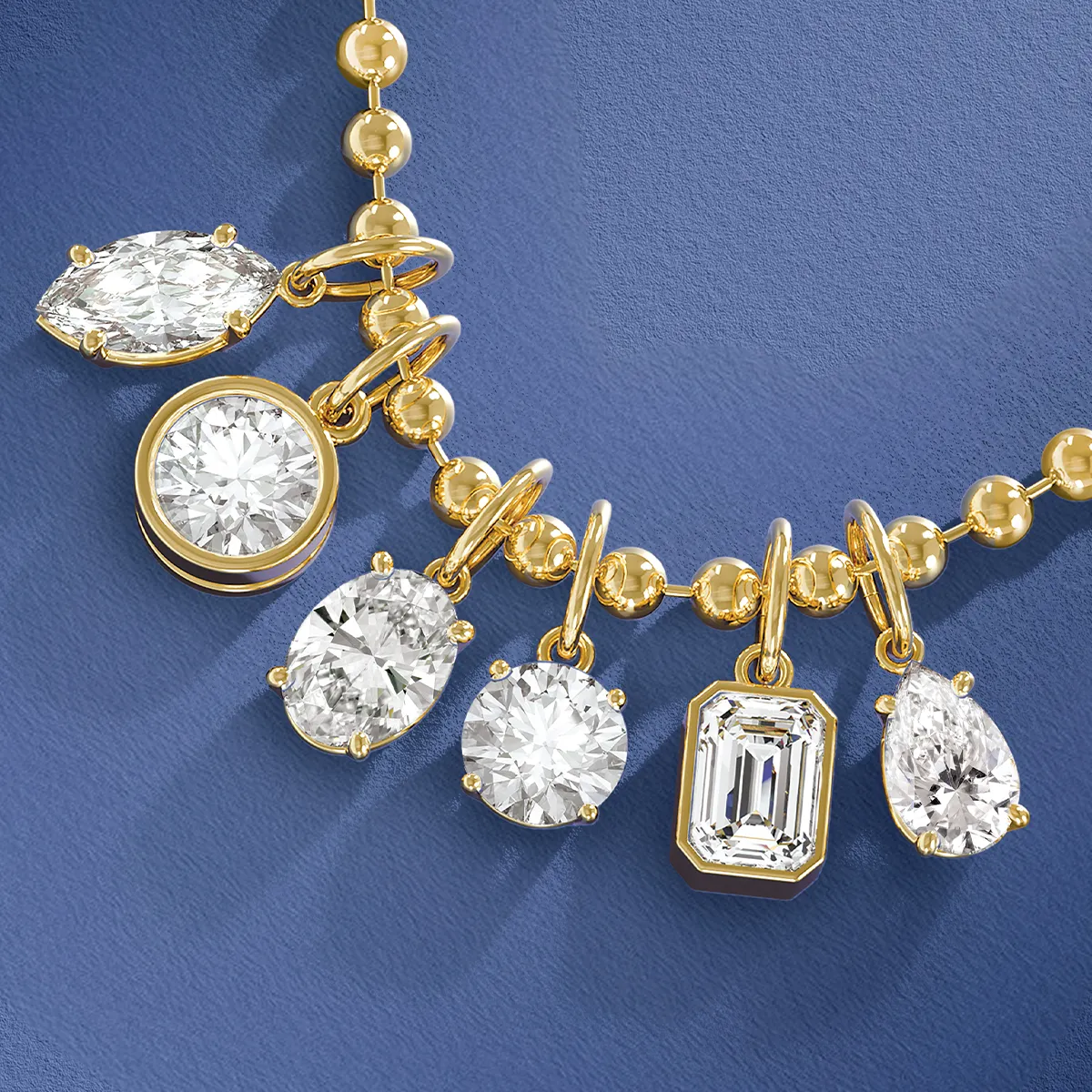 Gold necklace with various diamond pendants on a blue background.