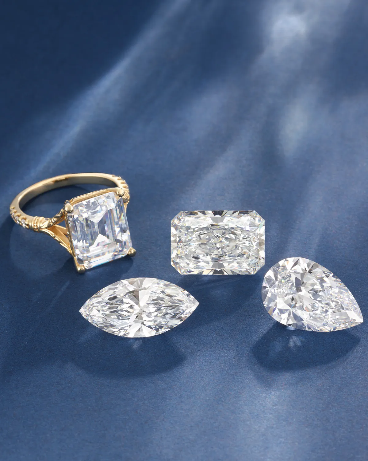 Gold ring and three loose diamonds on a blue surface. Learn more.