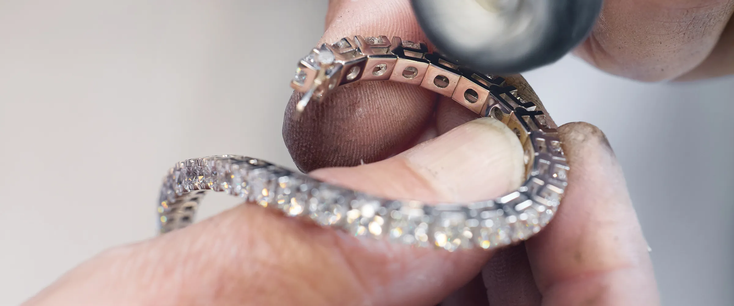 Jeweler polishing diamond bracelet. Explore the Care Club at Canton Jewelry.