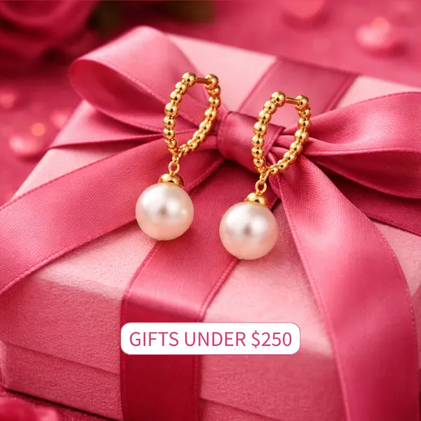 Gold pearl earrings on a pink gift box with a ribbon. Click to view gifts under $250 at Carroll / Ochs Jewelers.