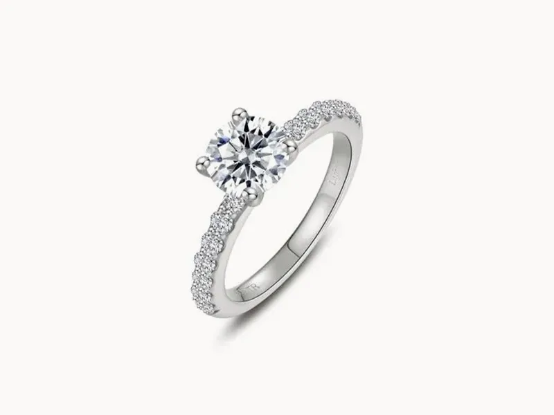 A silver engagement ring with a large central diamond and smaller diamonds on the band.