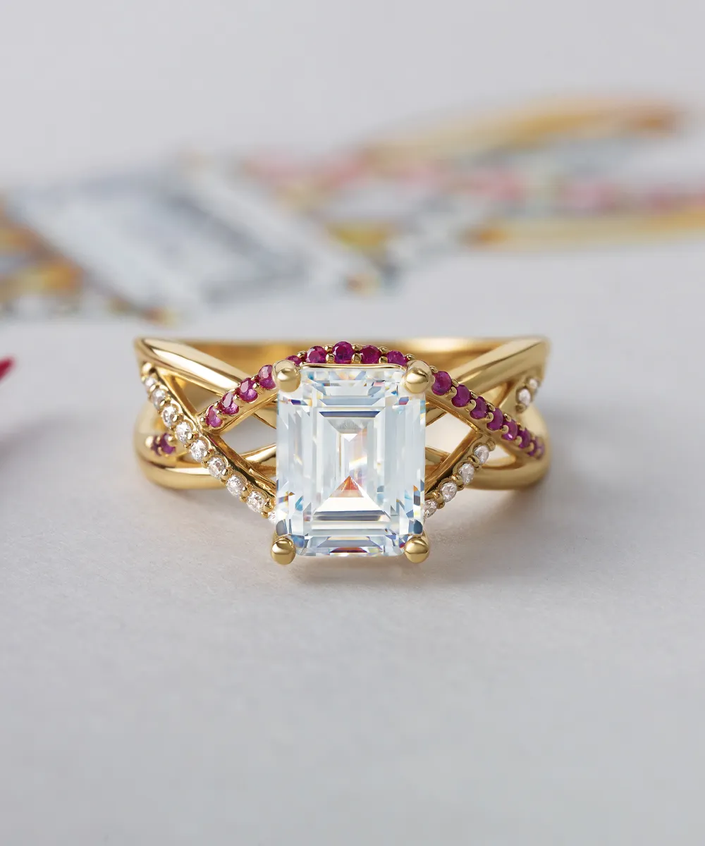 A gold ring with a large rectangular gemstone, accented by red and white stones in a crisscross design.
