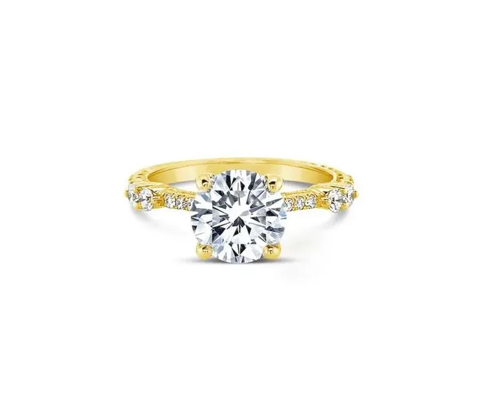 Elegant yellow gold engagement ring featuring a large round diamond center stone and smaller diamonds on the band.