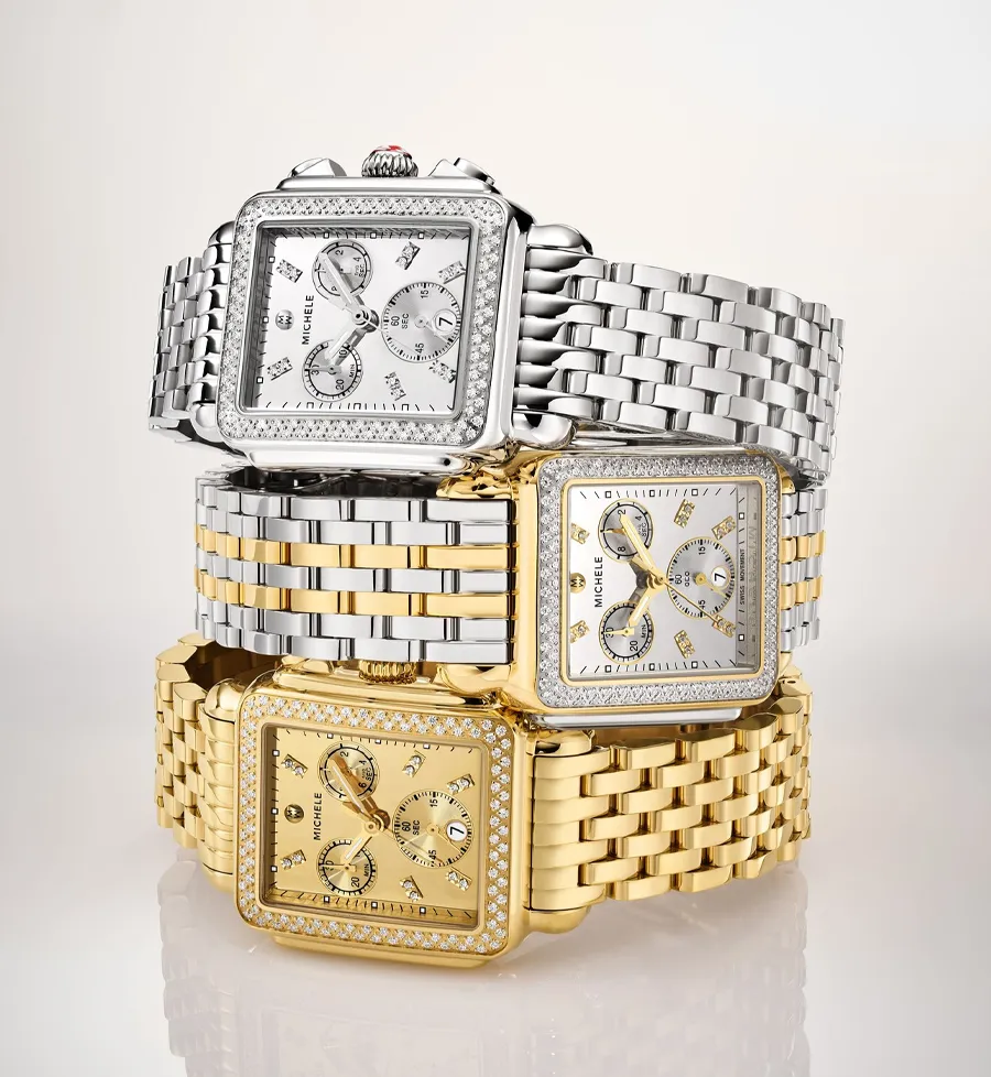 Three elegant Michele watches in silver and gold with diamond accents, showcasing luxury timepieces.