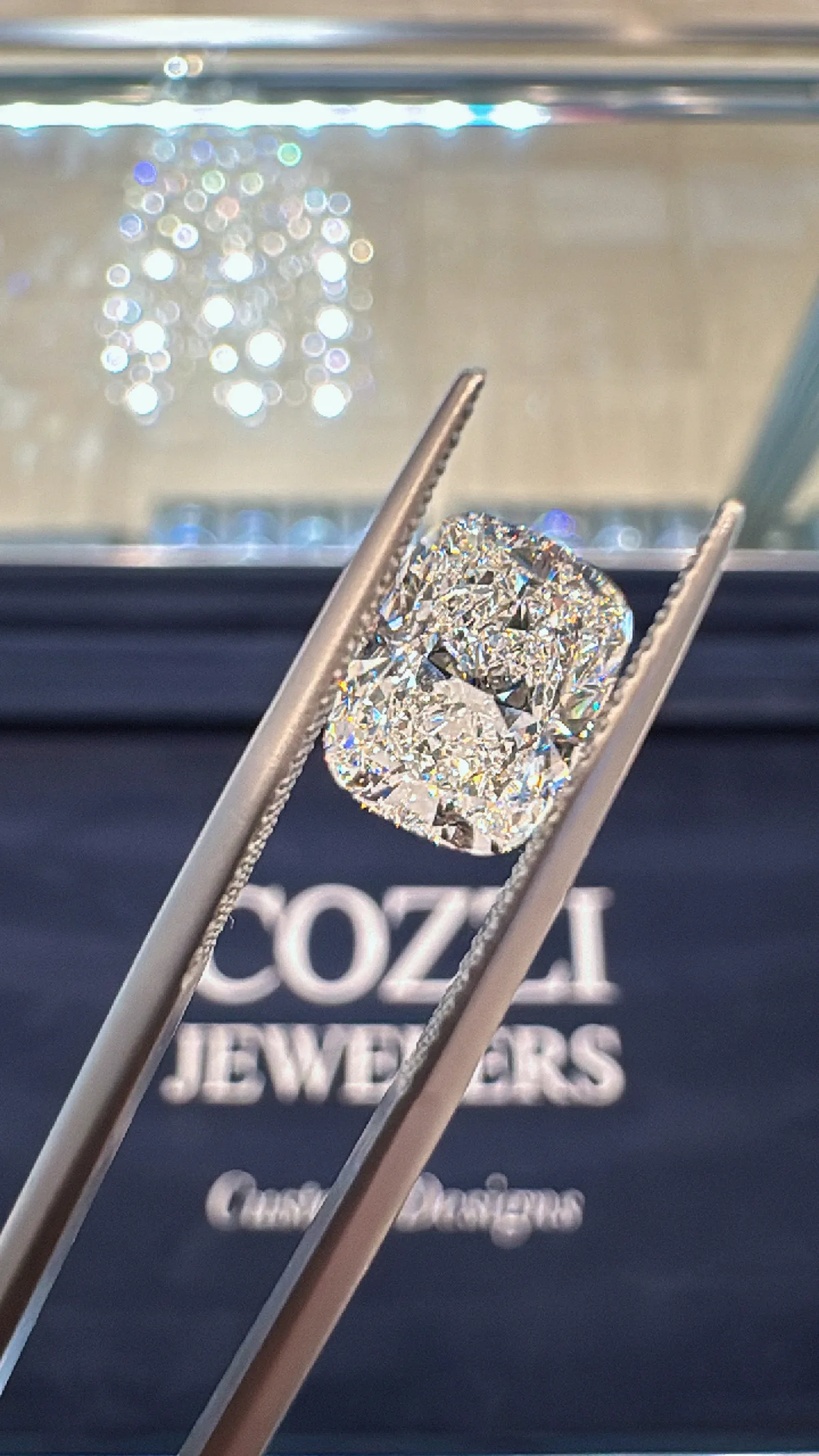 A sparkling diamond held by tweezers, showcasing its brilliance. Click to start your search for the perfect diamond.