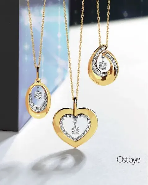 Ostbye rings with red stones on a gold background; click to explore more Ostbye designs at Dahlkemper's Jewelry Connection.