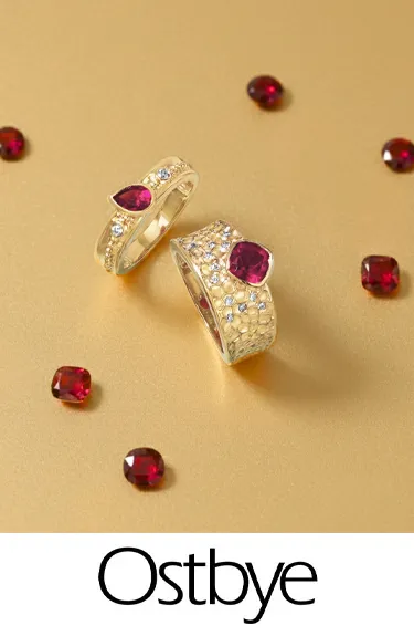 Ostbye rings with red stones on a gold background; click to explore more Ostbye designs at Dahlkemper's Jewelry Connection.