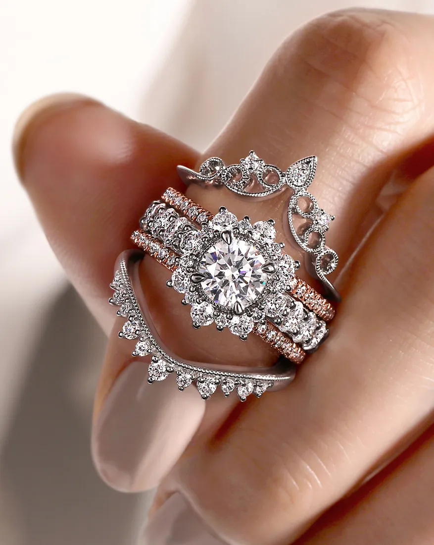 Close up of engagement ring inside a band enhancer on women's finger with manicured nails