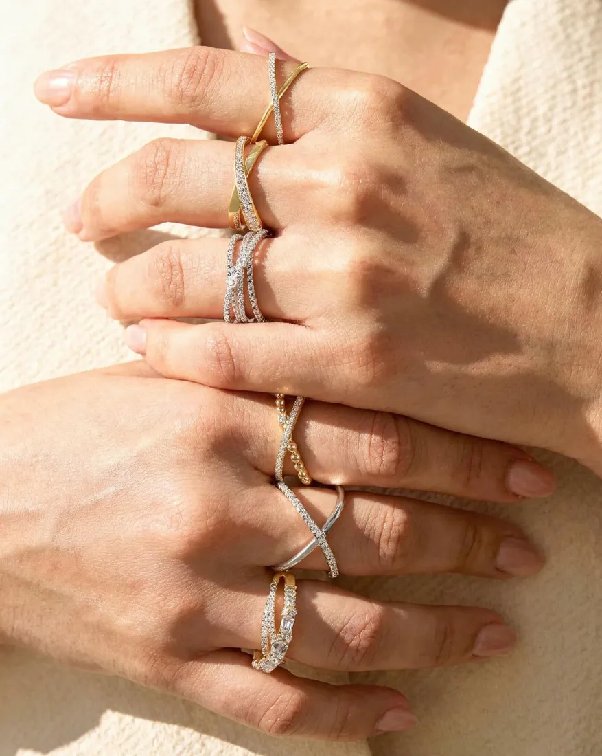 Hands adorned with multiple gold and silver rings. Click to explore Fashion Rings at Dahlkemper's Jewelry Connection.