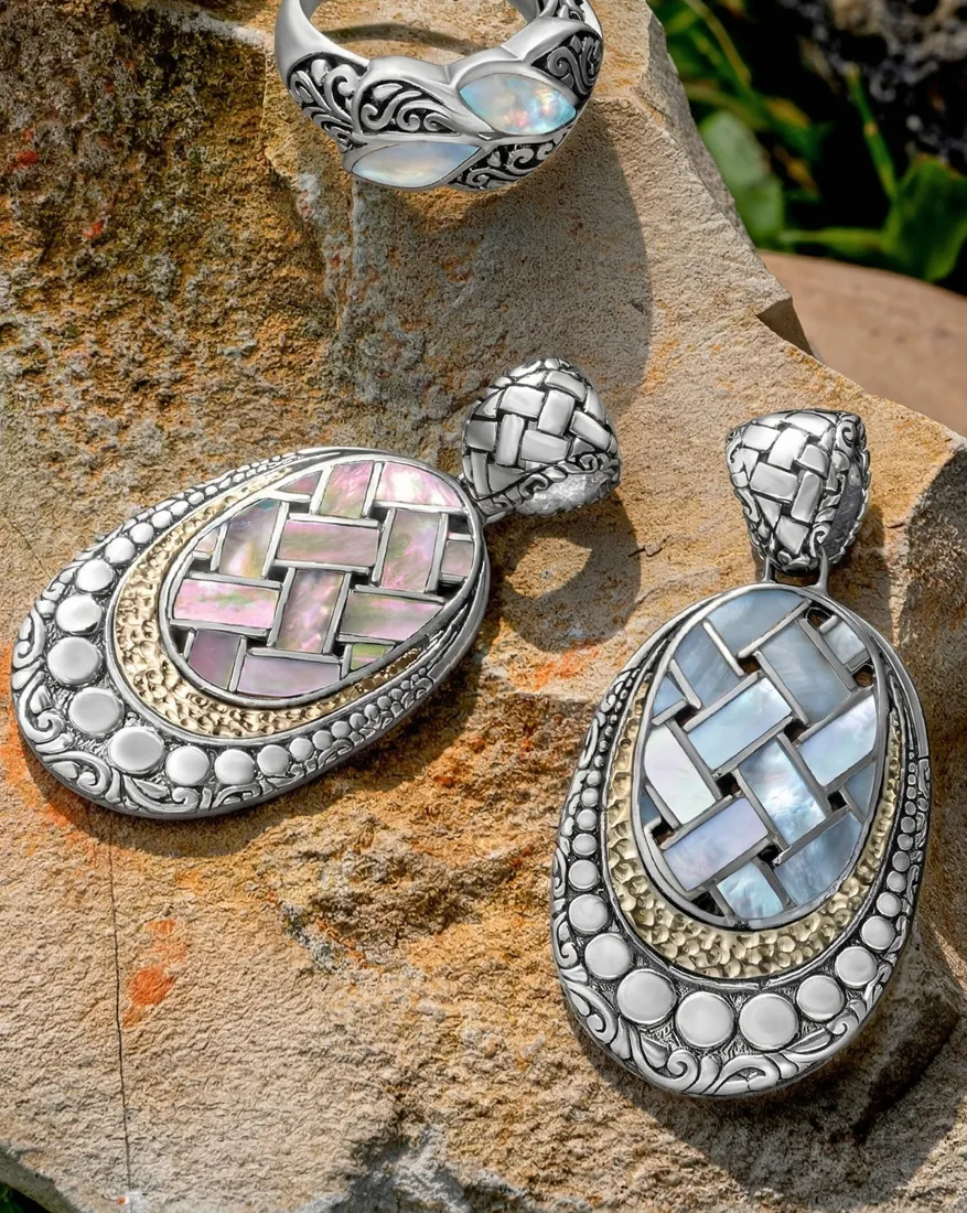 Intricate silver and colorful earrings and ring on a stone surface; explore more at Dahlkemper's Jewelry Connection in Er