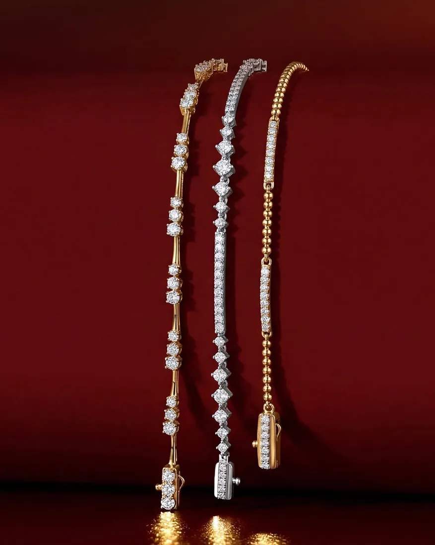 Four elegant diamond bracelets in gold and silver on a rich red background.