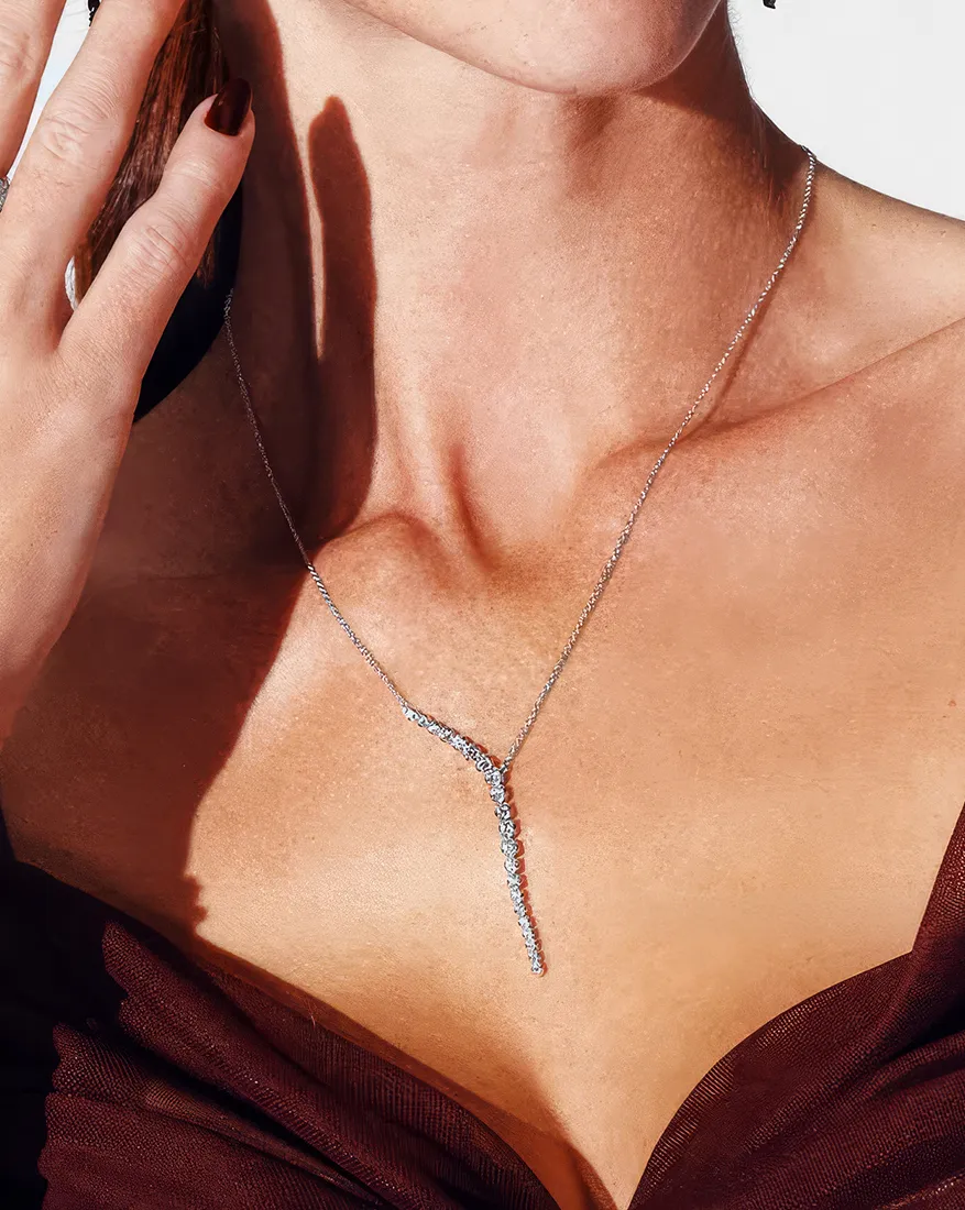 Diamond pendant with intricate design on a twisted silver chain.