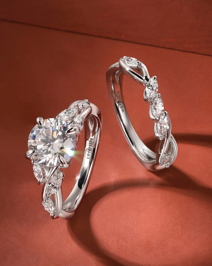 Two elegant diamond rings with intricate designs on a brown surface.