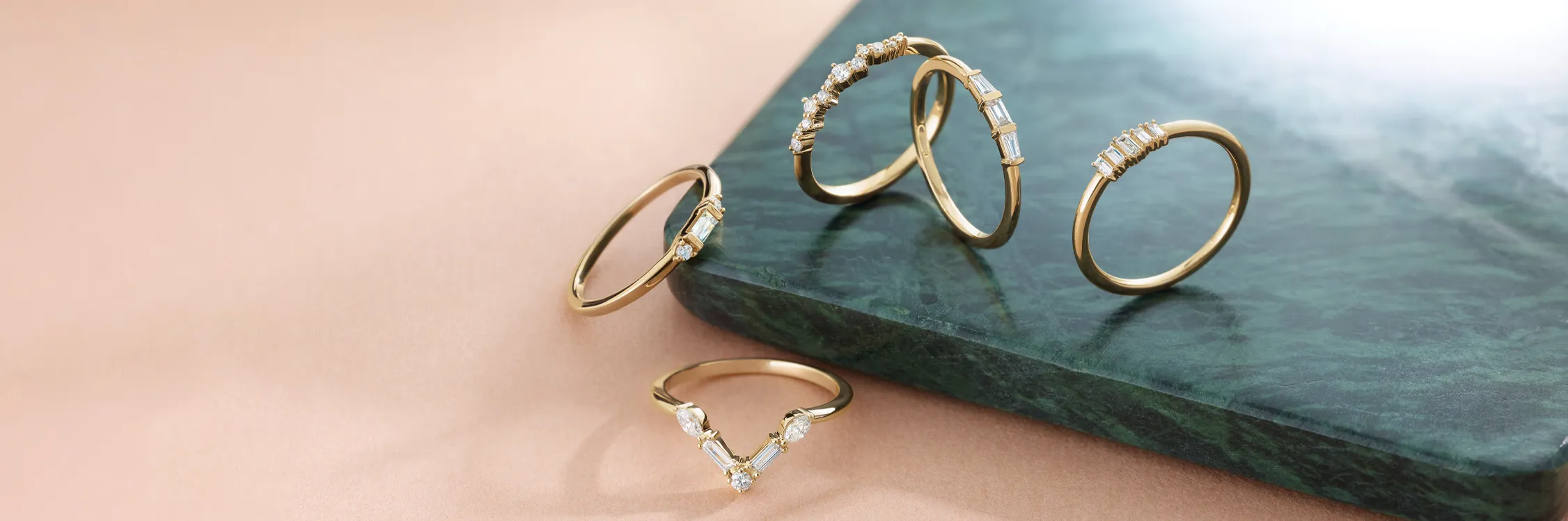 Model showcasing elegant jewelry, including rings and earrings, with a soft focus background.