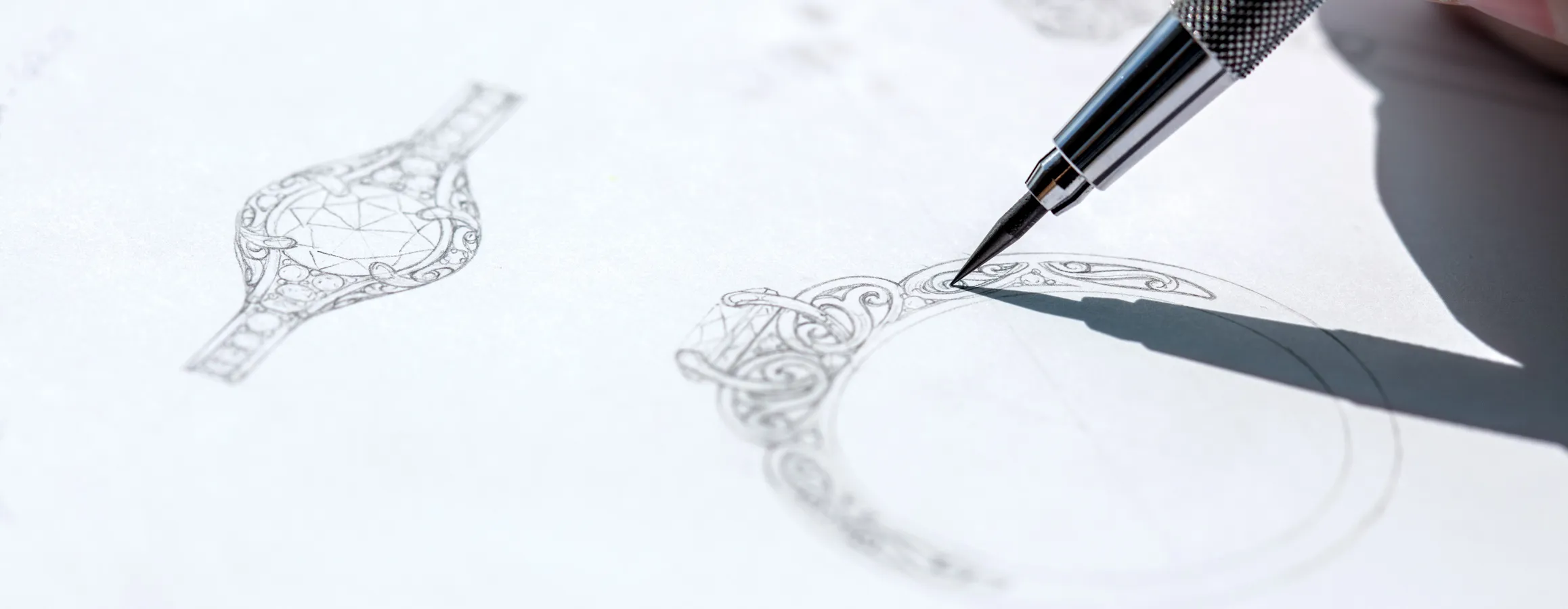 A hand drawing intricate jewelry designs with a pen on paper, showcasing creativity and craftsmanship.