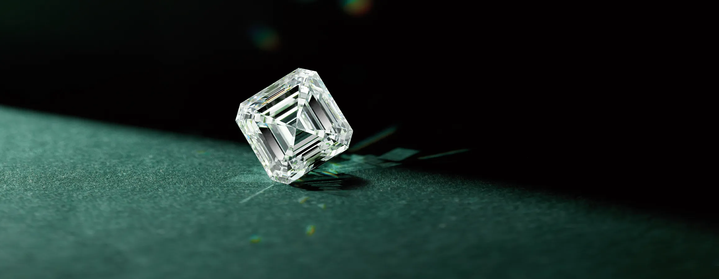 A sparkling diamond on a dark surface, showcasing its brilliance and clarity. Click to make an appointment for a consultation.